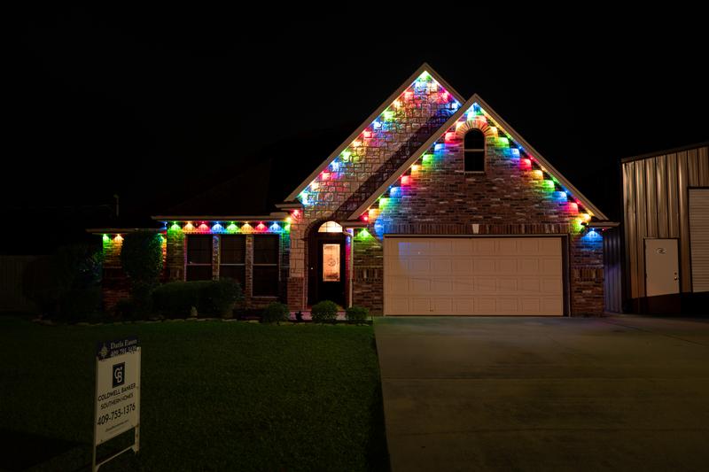 Front exterior with multicolor permanent holiday lights at night