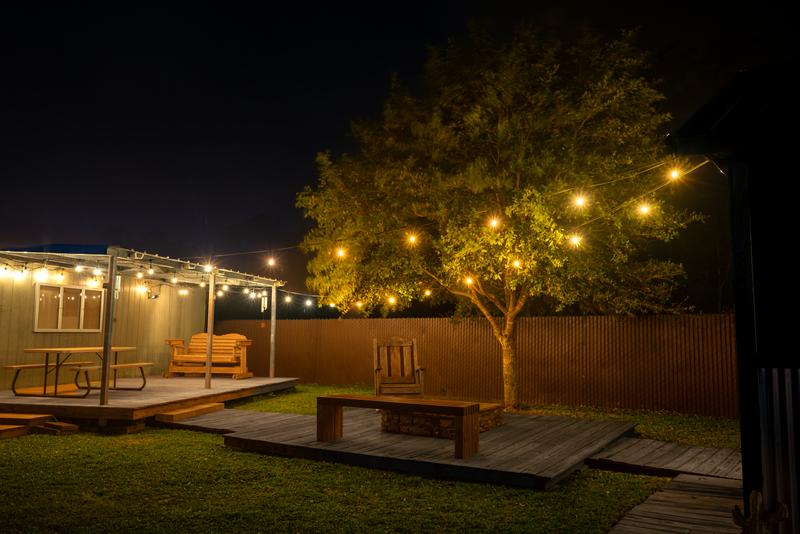 Backyard seating area with string lights at night