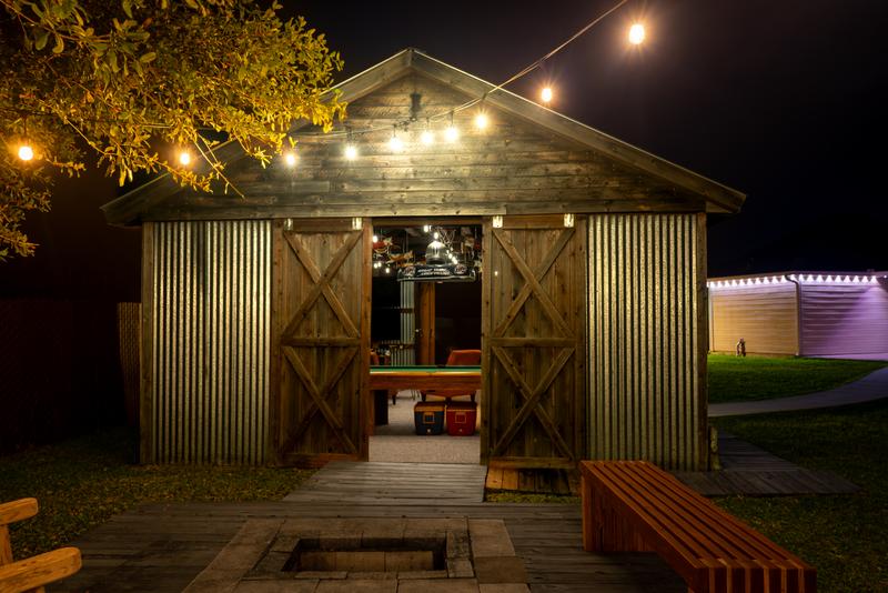Game building barn doors open with fire pit at night