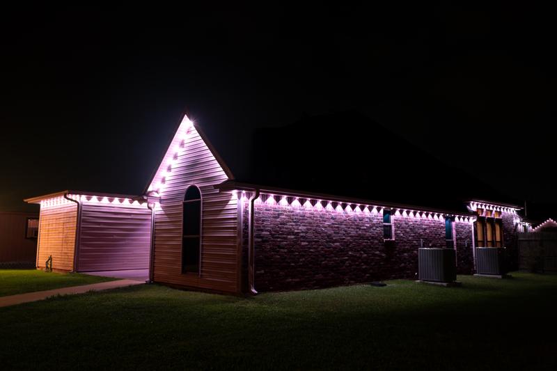Side exterior with purple permanent holiday lights at night