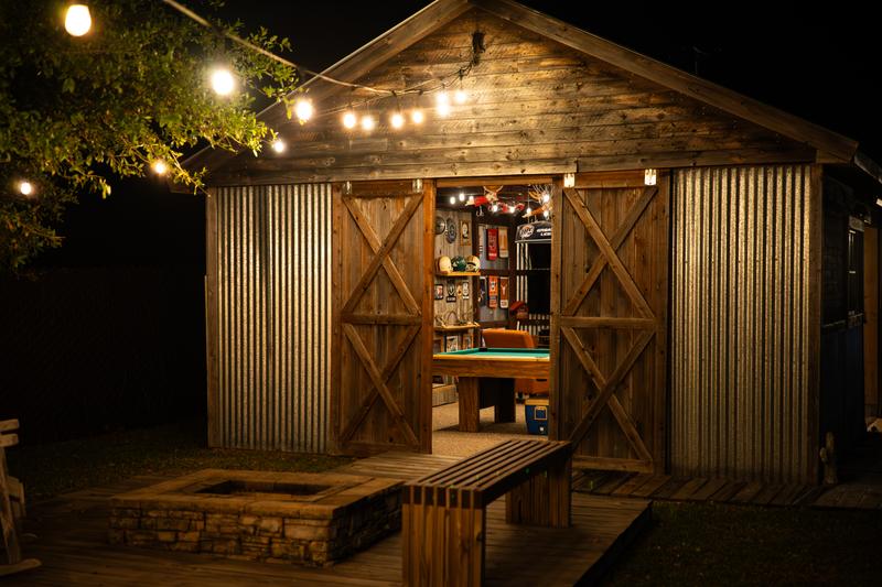 Game building exterior with fire pit and string lights