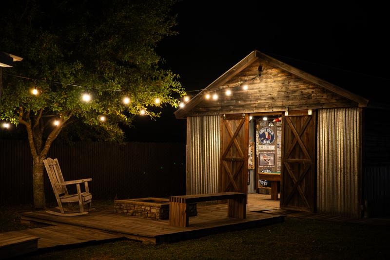 Game building exterior with rocking chair and string lights